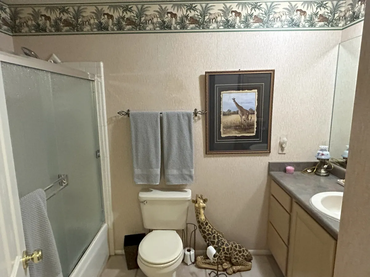 The scene captures a cheerful bathroom with playful giraffe-themed decor, including a figurine and artwork, complemented by soft towels and modern fixtures. The mood is light-hearted, perfect for family routines and fun moments.